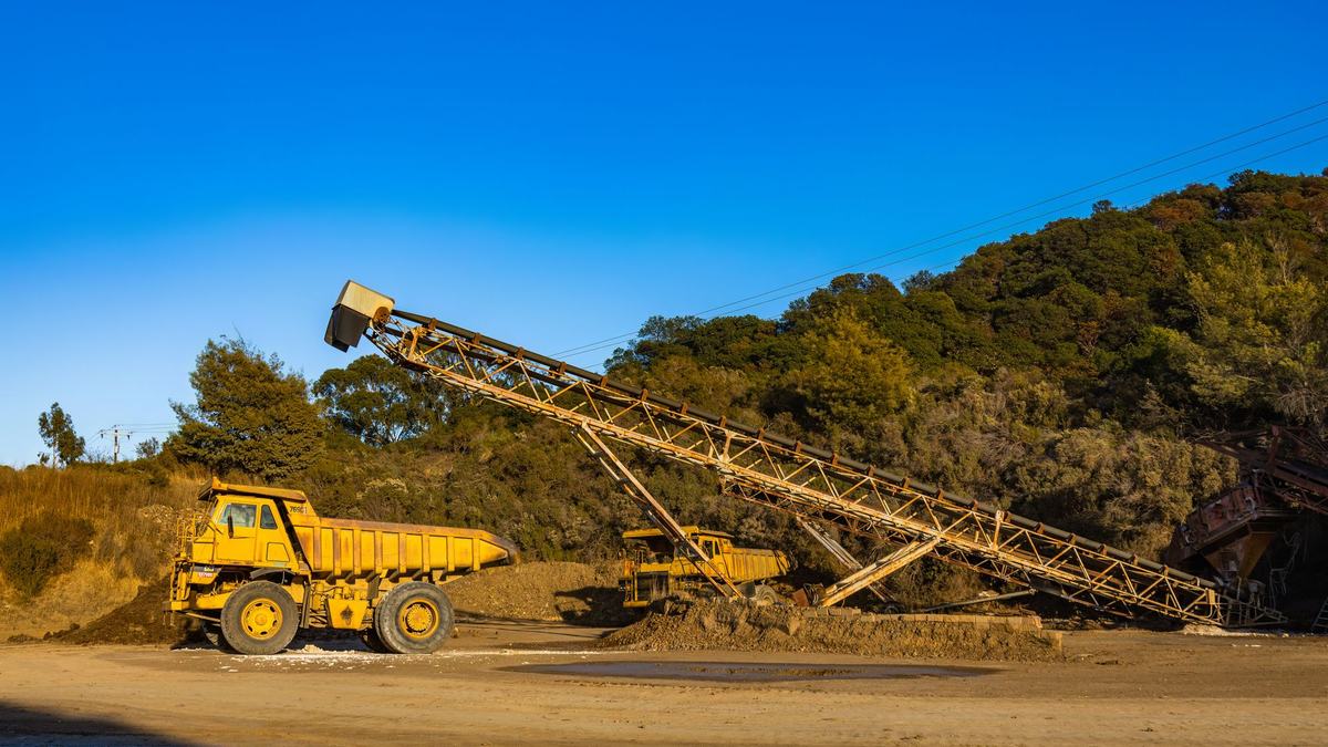 Haul truck alongside a conveyor at an industrial site