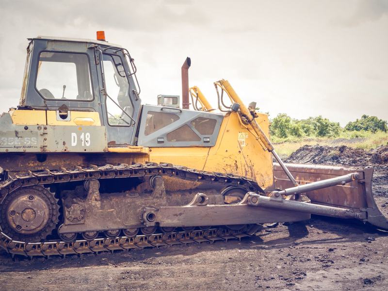 Track dozer with its blade lowered on cleared ground