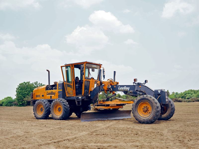 Motor grader parked on a gravel surface