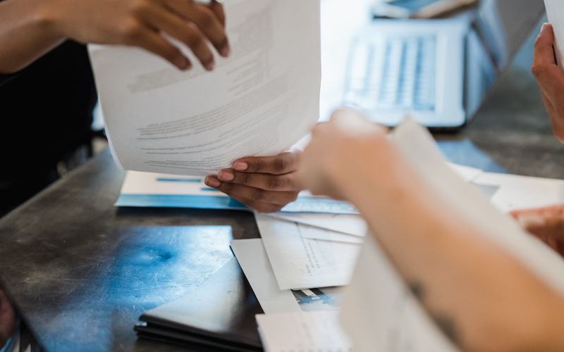 Asset schedules and a laptop on a desk during a valuation
